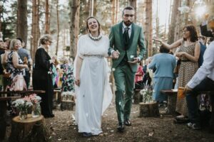 Due sposi eleganti durante un matrimonio sostenibile, indossando abiti ecologici.