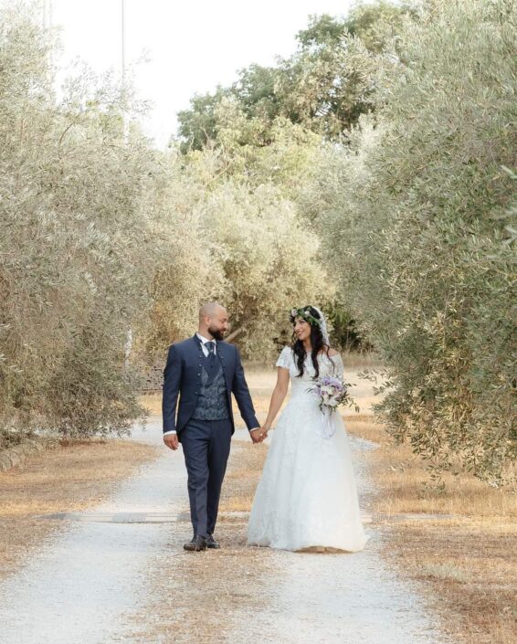 Coppia di sposi cammina mano nella mano tra ulivi in una location naturale, matrimonio a Viterbo