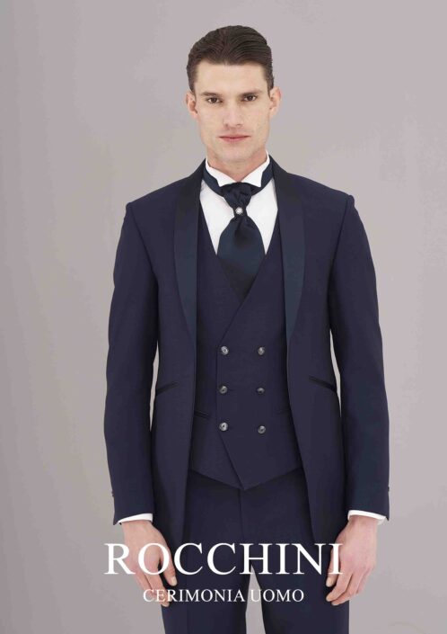 Modello in smoking-marsina blu navy con gilet doppio petto blu chiaro, cravattone con spillone gioiello, ideale per matrimonio a Viterbo