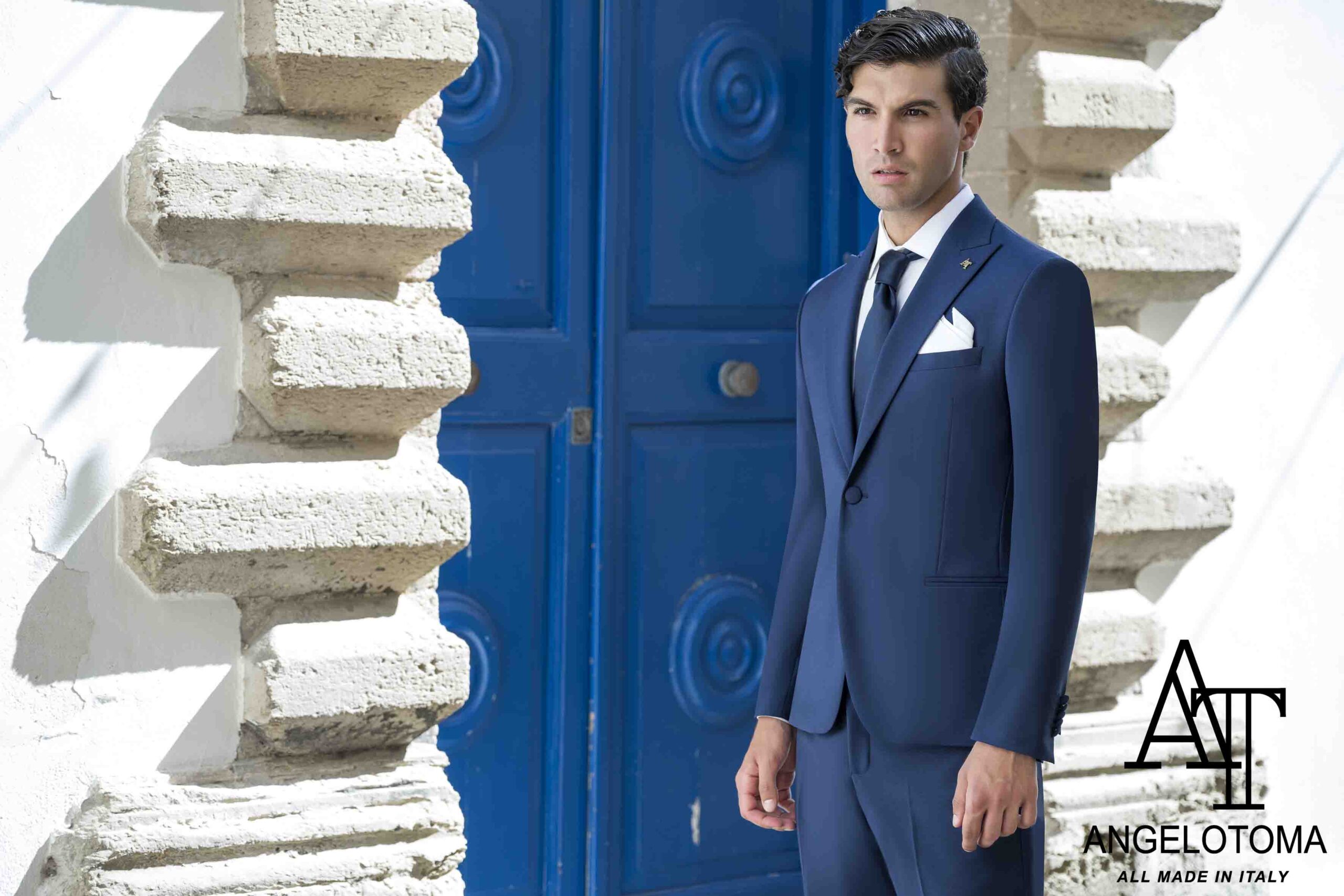 Uomo in abito elegante blu, stile classico, con sfondo architettonico mediterraneo – Abiti eleganti per lo sposo a Viterbo.